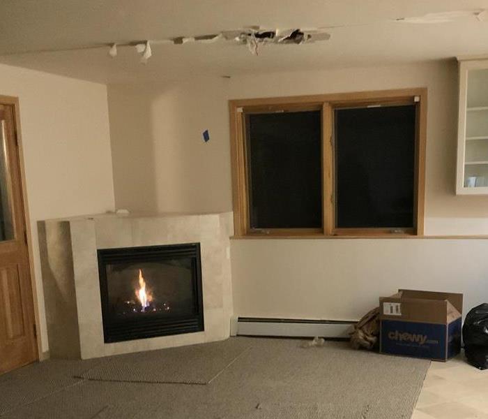 Living room with a hole in the ceiling.