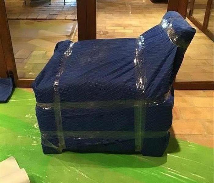 a chair wrapped in blue protective materials. 